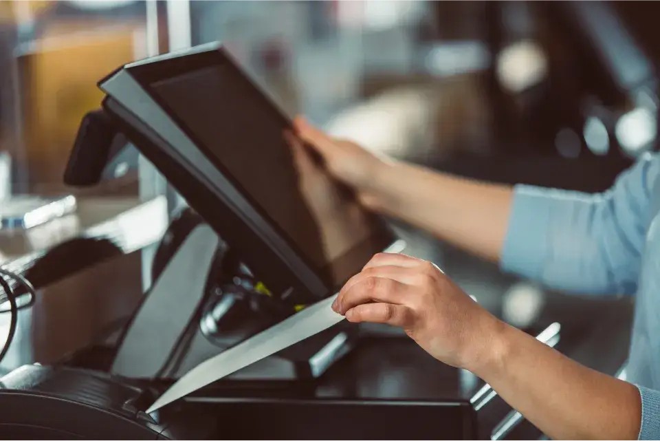 Close-up of hands using a KassenSichV-compliant cash register