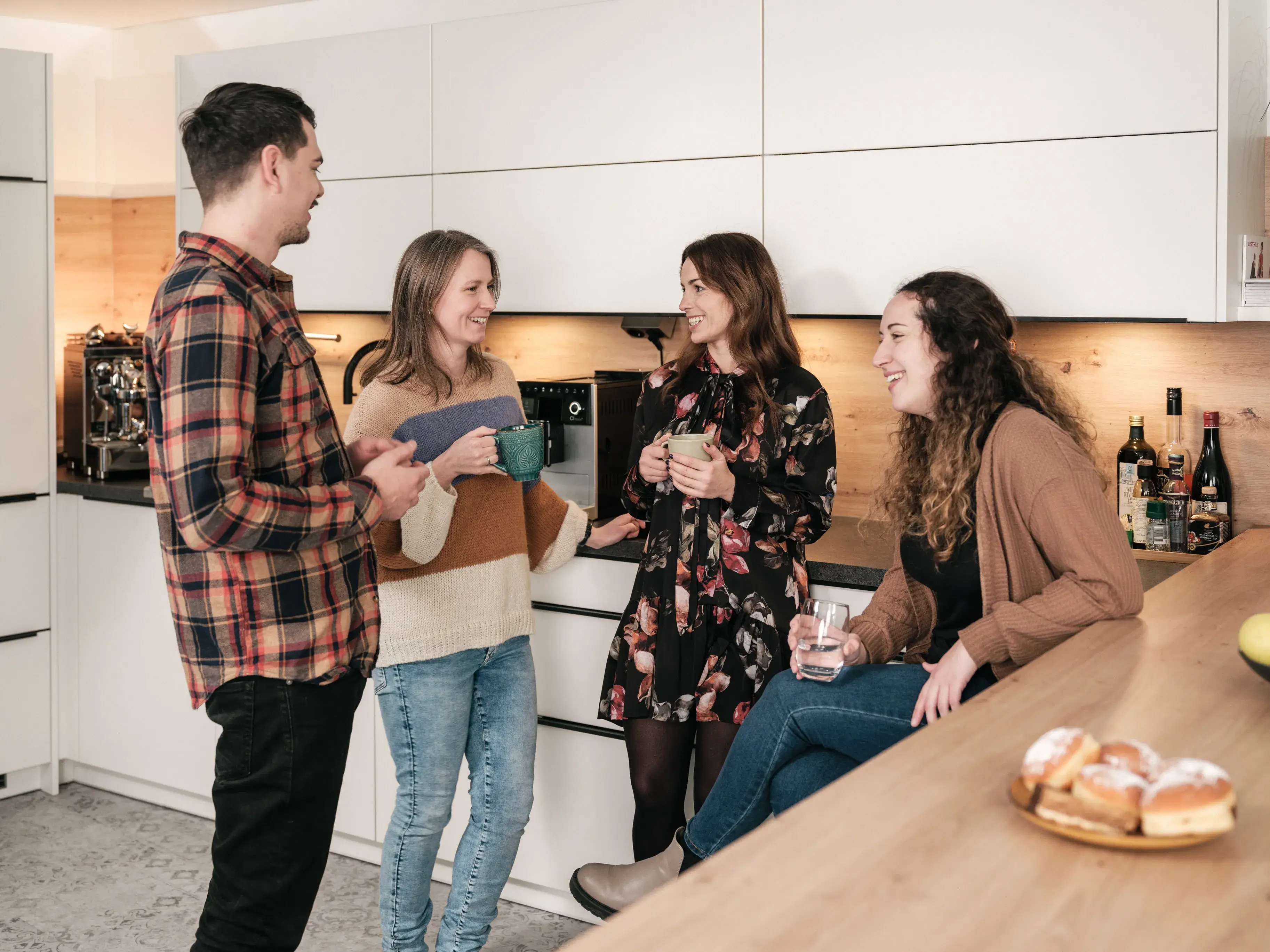 fiskaly employees chat nicely in the kitchen in Vienna office with coffee mugs about fiskaly culture, fiscalization and electronic receipts